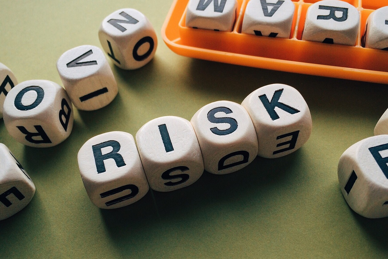 Dice blocks arranged on a table, spelling the word "risk" in a creative display